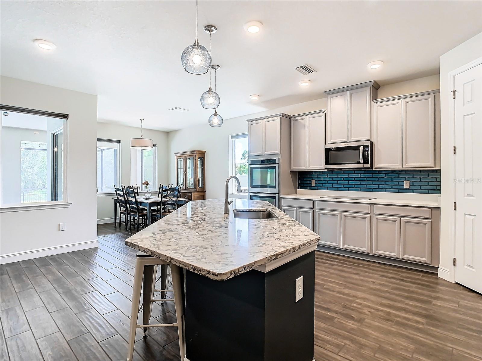 Kitchen has island with granite countertops.