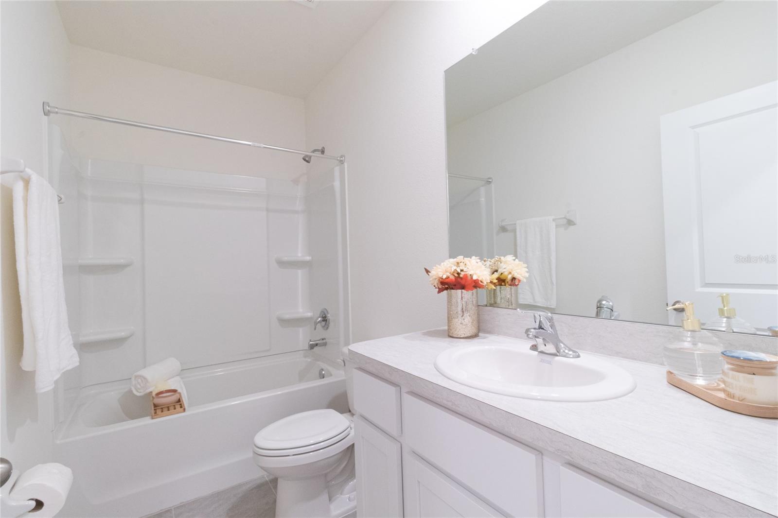 Bright and airy bathroom perfect for a refreshing start to your day! Enjoy the pristine, modern design with plenty of counter space and a convenient shower/tub combo - ideal for quick showers or long, relaxing baths.