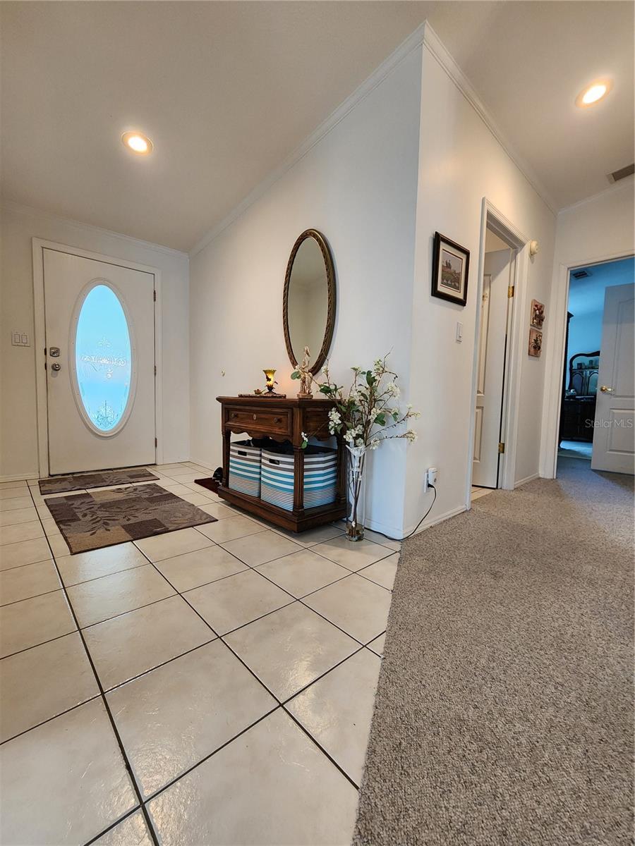 Entry foyer & hallway to laundry room and primary bedroom.