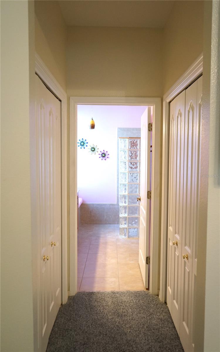 his and her closets in hallway to bathroom