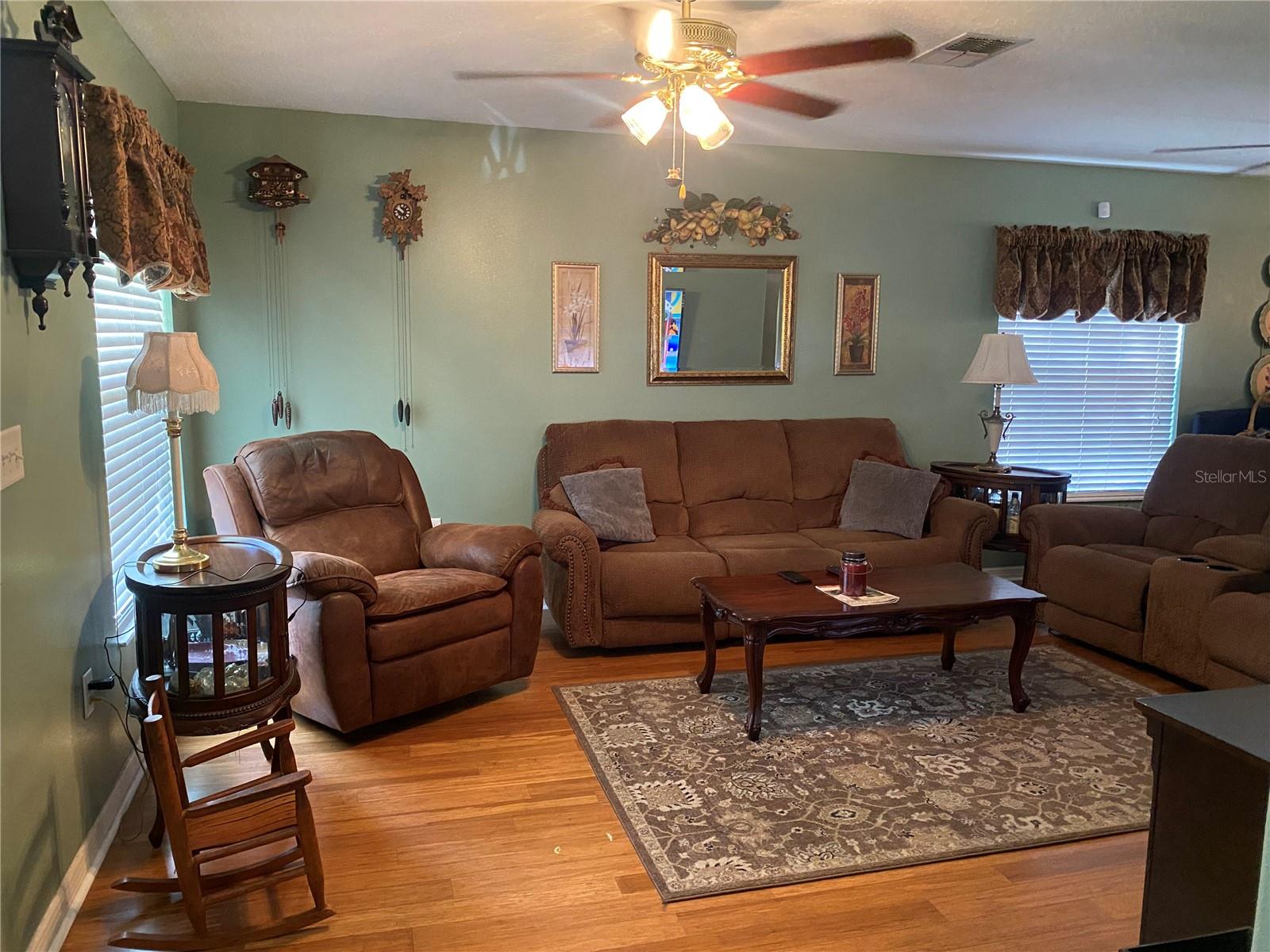 Living room with newer wood flooring and faux blinds