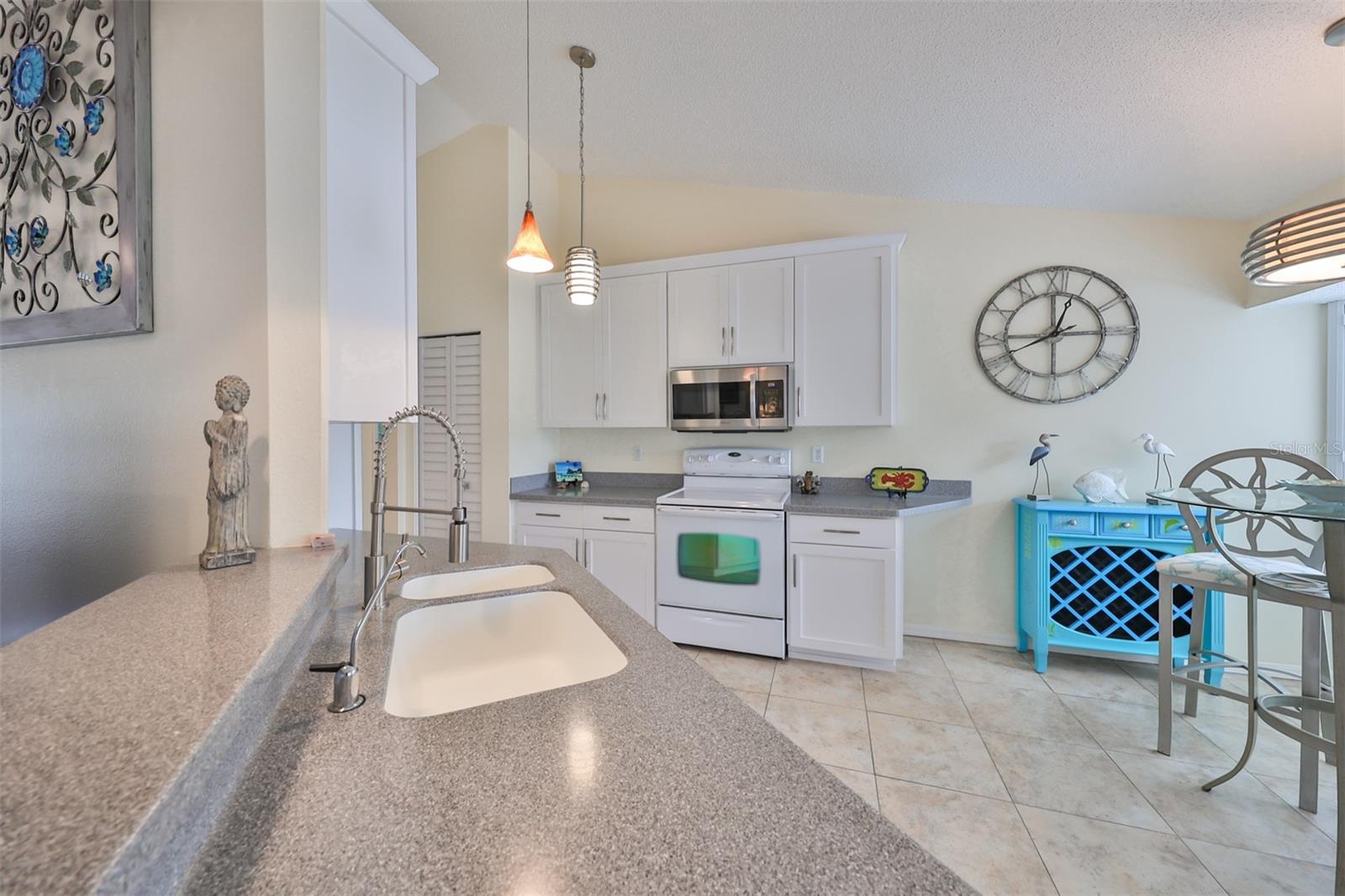 Spotless, open kitchen with lovely Corian counters and dinette space.