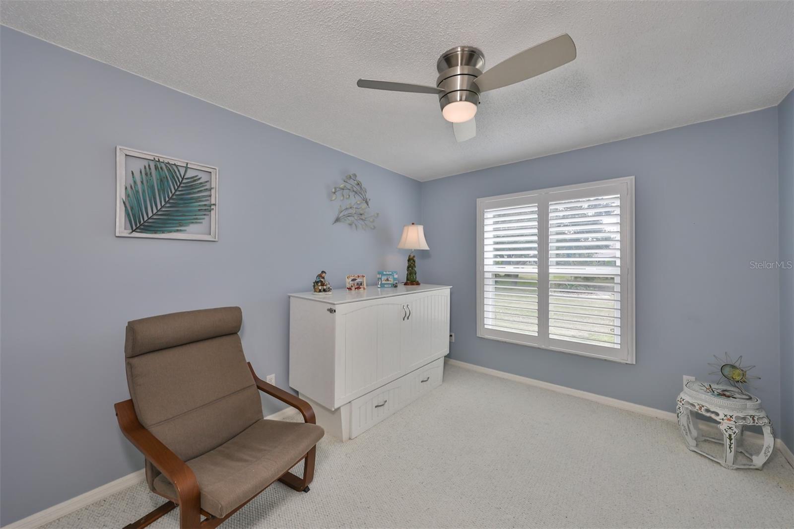 A murphy bed with drawer storage conveys with the home.  A view of the water through the plantation shutters is such a pleasure.