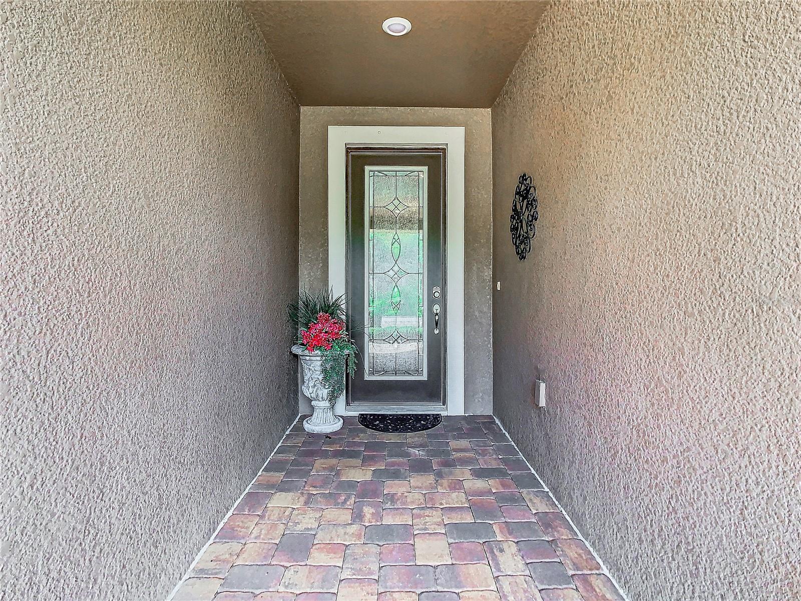 Pavered walk way to the decorative, glass front door. So nice!