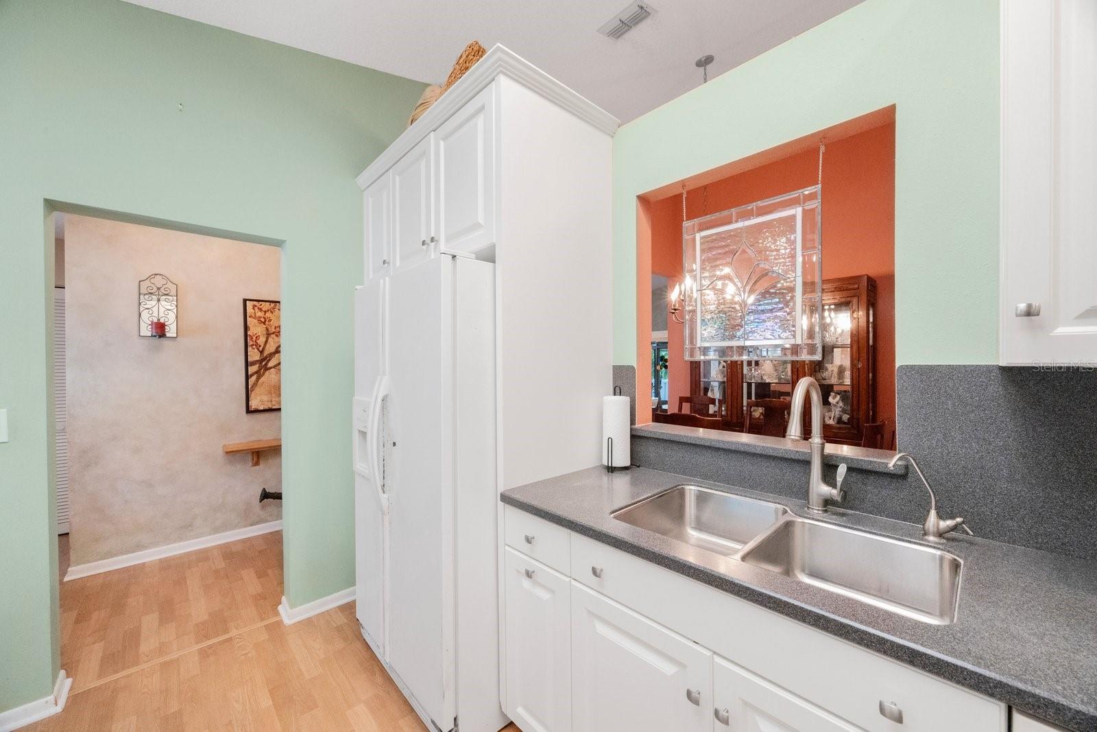 View of passthru from kitchen, stainless sink and filtered water dispenser