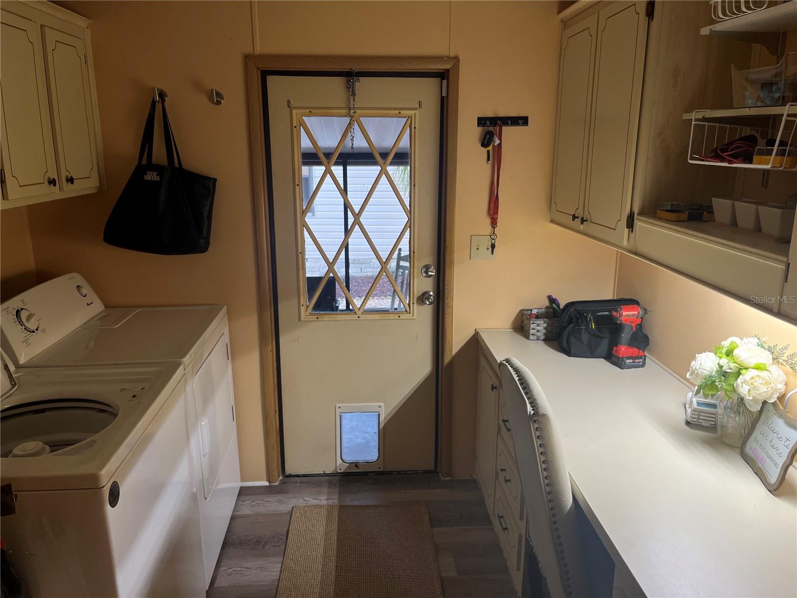 Laundry Room with built in desk and exterior door to outdoors