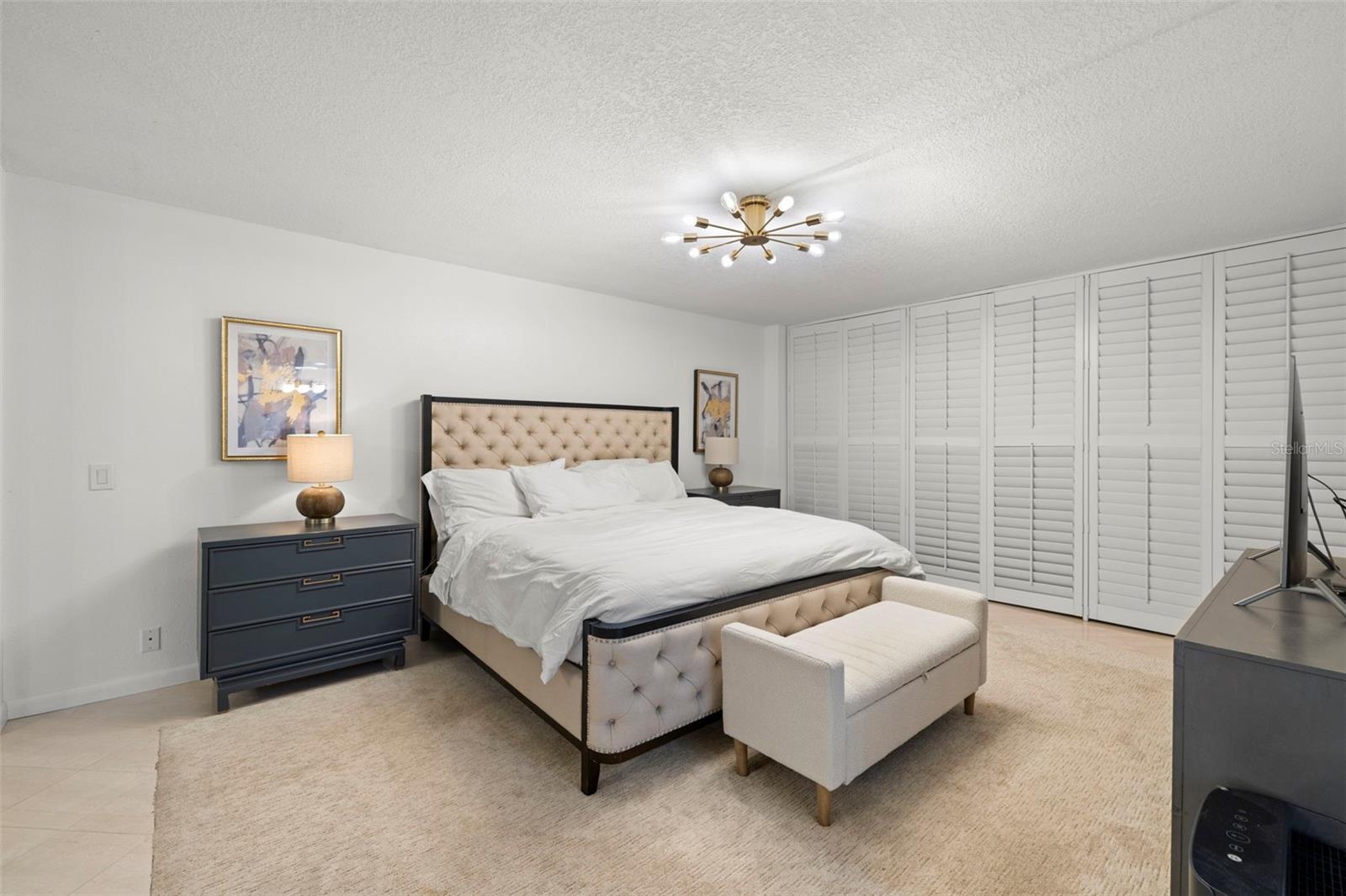 PRIMARY BEDROOM WITH PLANTATION SHUTTERS LEADING TO THE BALCONY