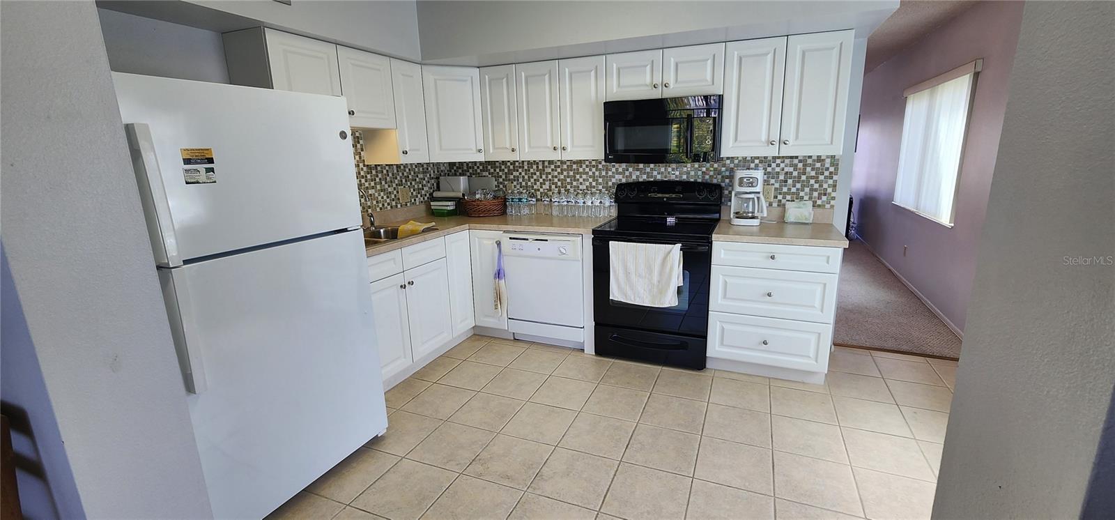 KITCHEN WITH UPDATED CABINETS AND BACKSPLASH