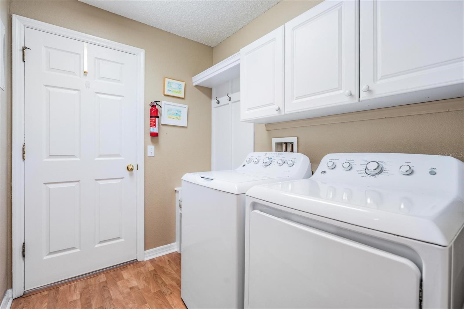 Walk-in laundry room also provides additional storage cabinets