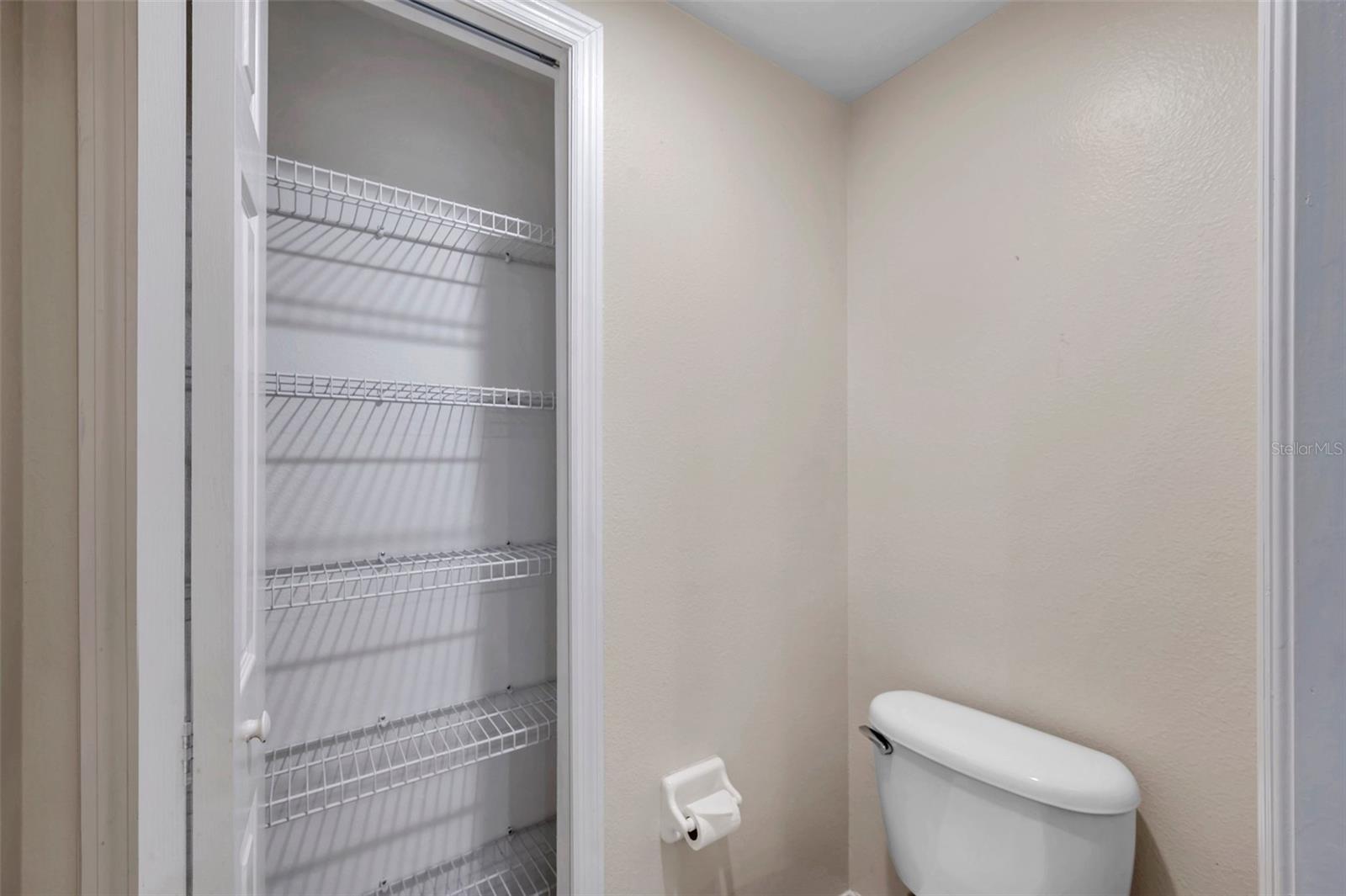 Private toilet with linen closet.