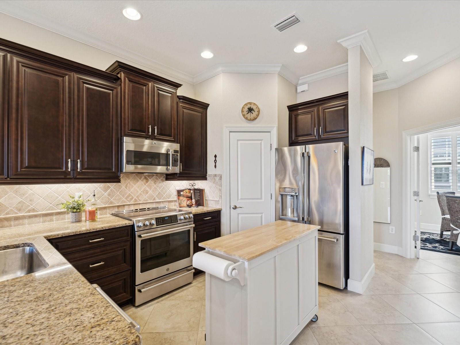 Kitchen with granite, stainless appliances and tile floor.