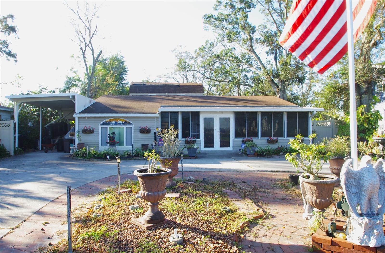 View showing front of the lovely home,  RV-height carport on left and large circular driveway for plenty of parking.