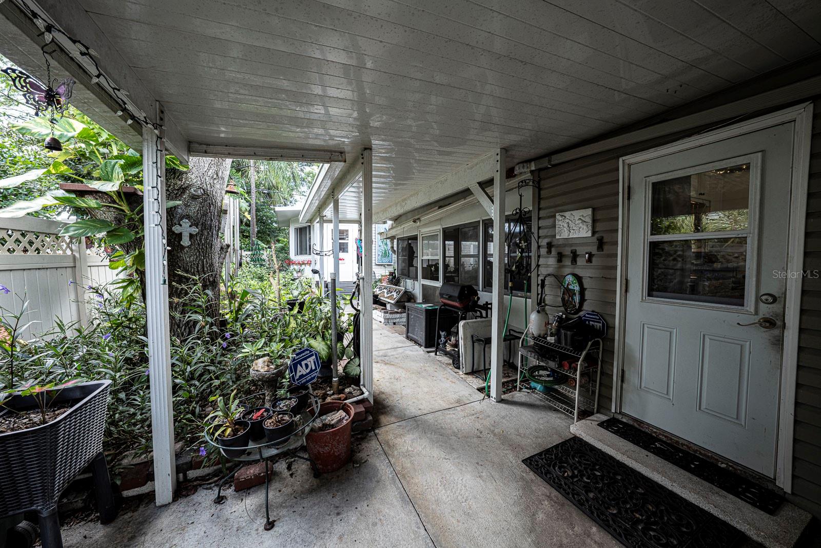 East side, covered patio at end of carport. Door leads to the kitchen.