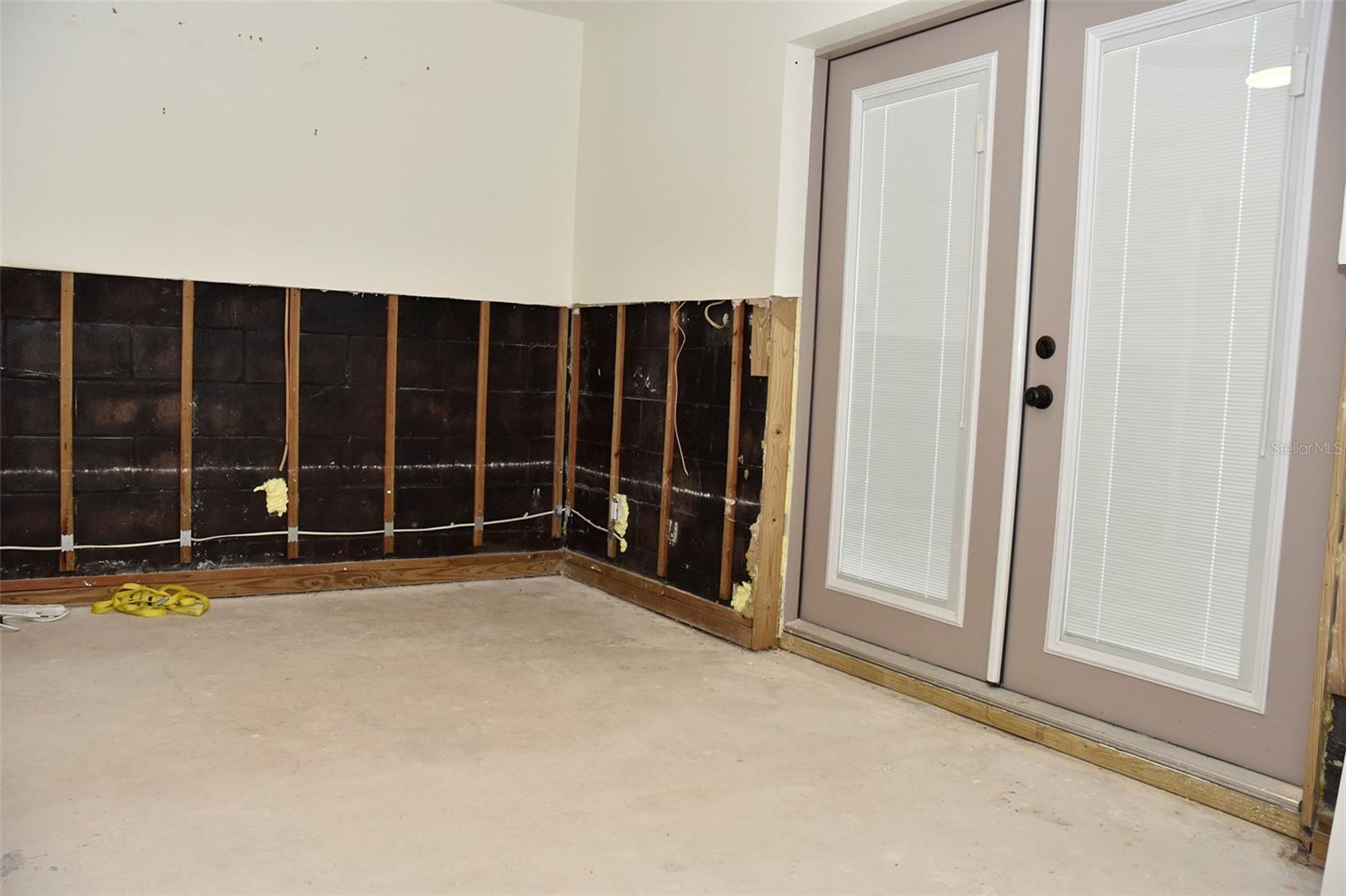 Bedroom 3 with french doors that lead to the pool. Current condition after mitigation of floodwater was done within 48 hours of the storm. 10/16