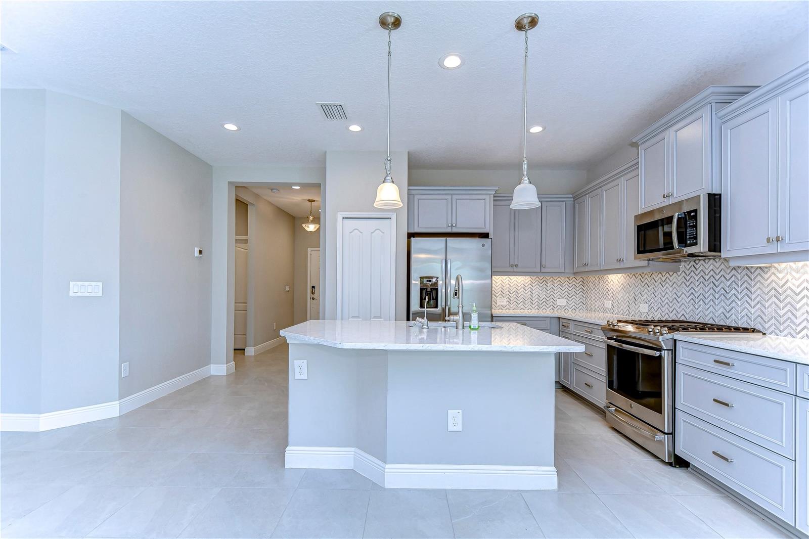 Sleek stainless appliances, and stunning 42” gray cabinets adorned with crown molding!