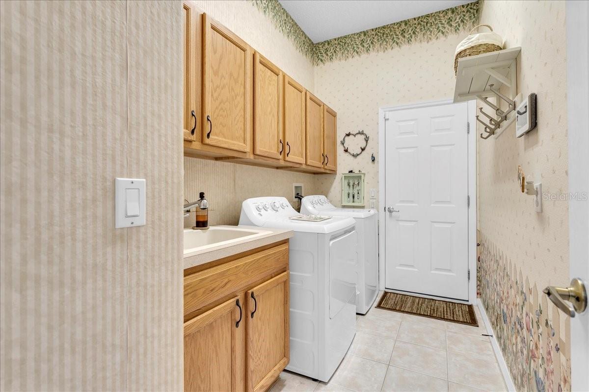 Large laundry room with utility sink and storage