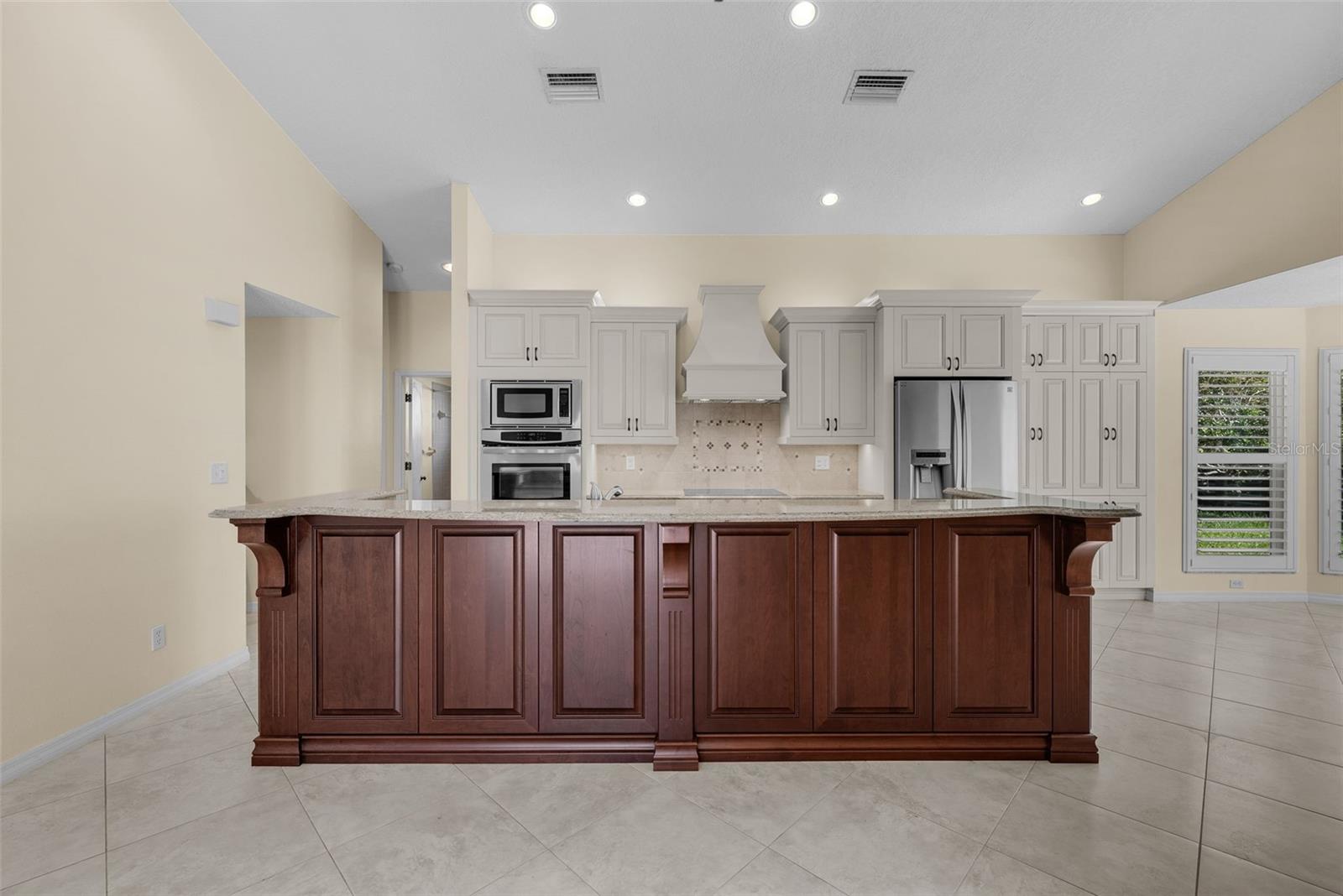 A dreamy kitchen with custom cabinetry, large pantry, oversized island and breakfast bar for joy in entertaining.