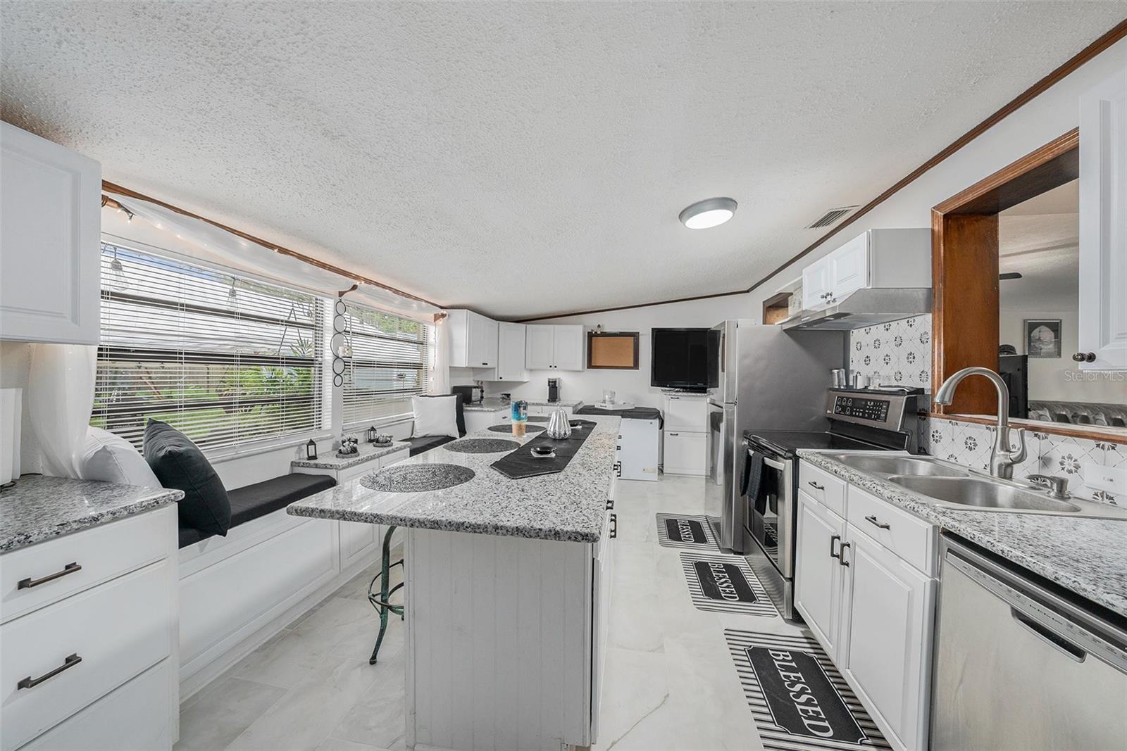 Updated kitchen w/a breakfast bar, granite counters,new stainless steel appliances, new tile flooring & new cabinets 3