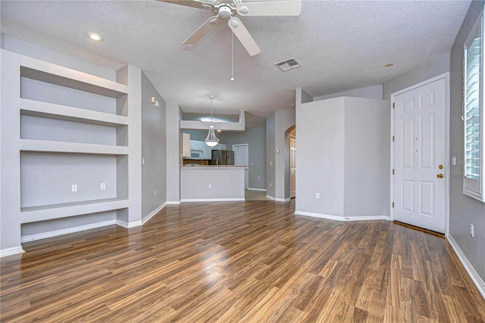 Front Entry door; open living room; kitchen