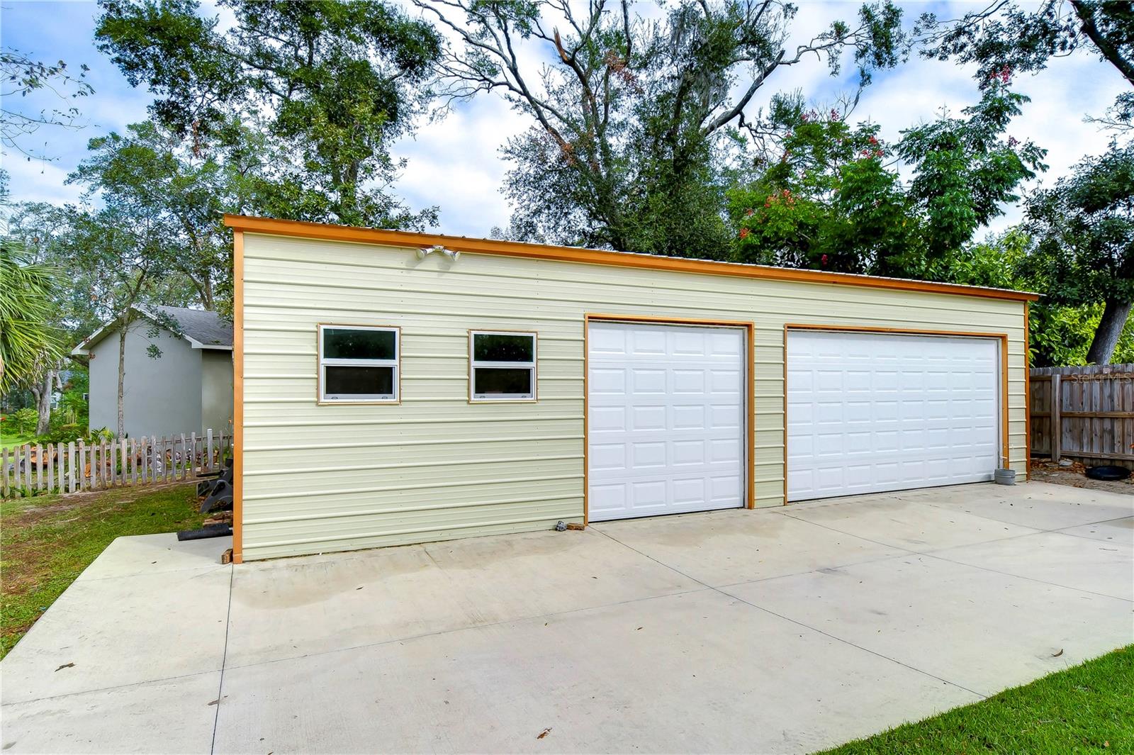 960-square-foot structure offers exceptional functionality with a tin roof, dual garage doors (16' and 8’) with plenty of room to add a third door, making it perfect for multiple vehicles or large equipment!