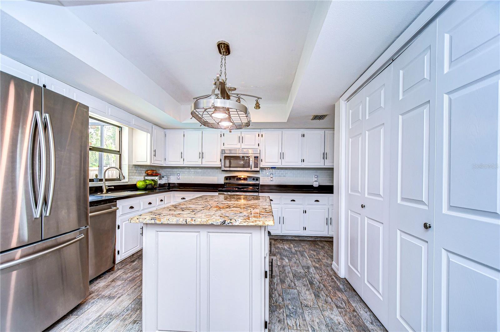 Spacious kitchen with Corian & granite counters and sleek stainless appliances!