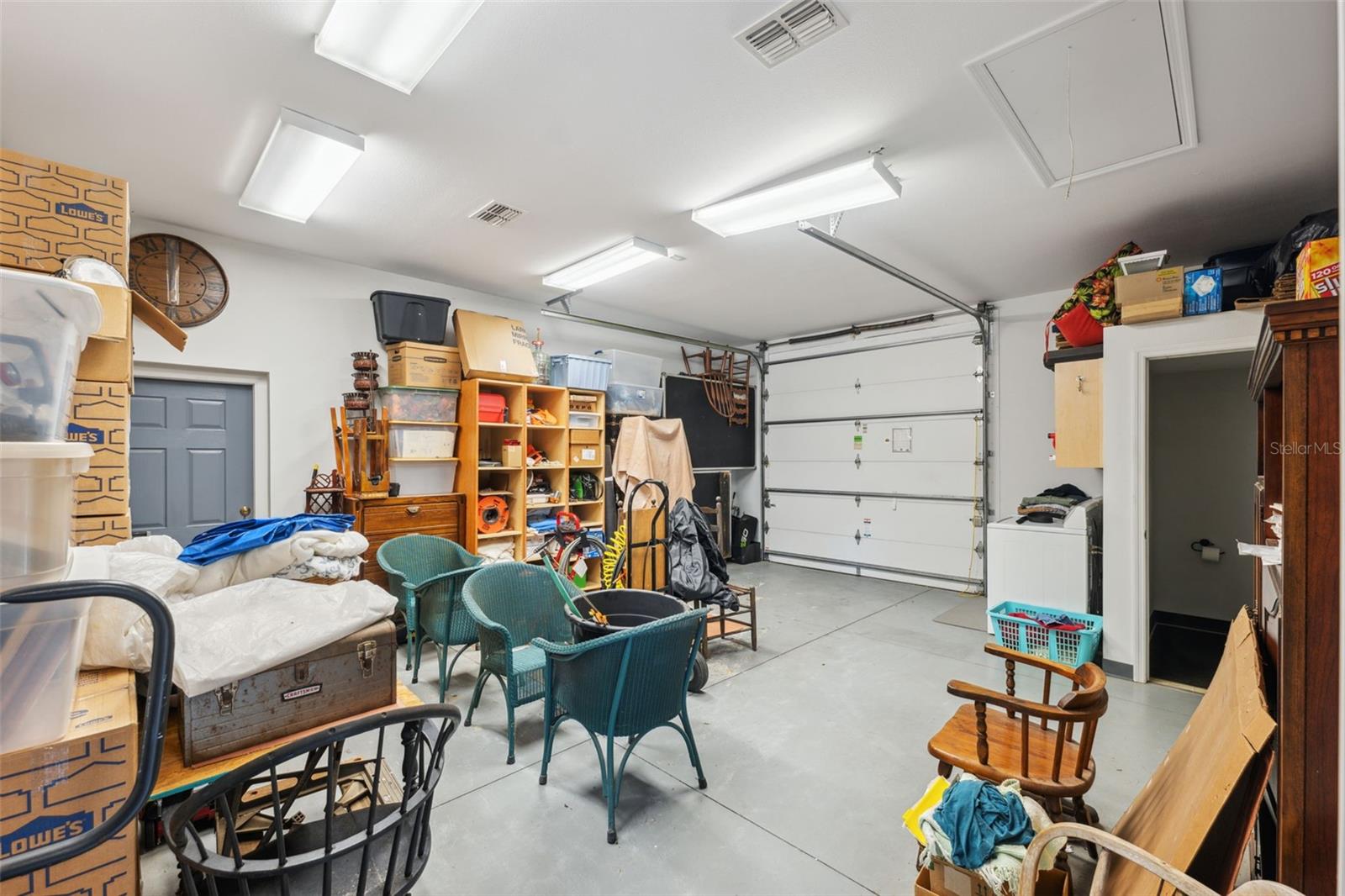 Interior of workshop, showing garage door and inside bathroom.