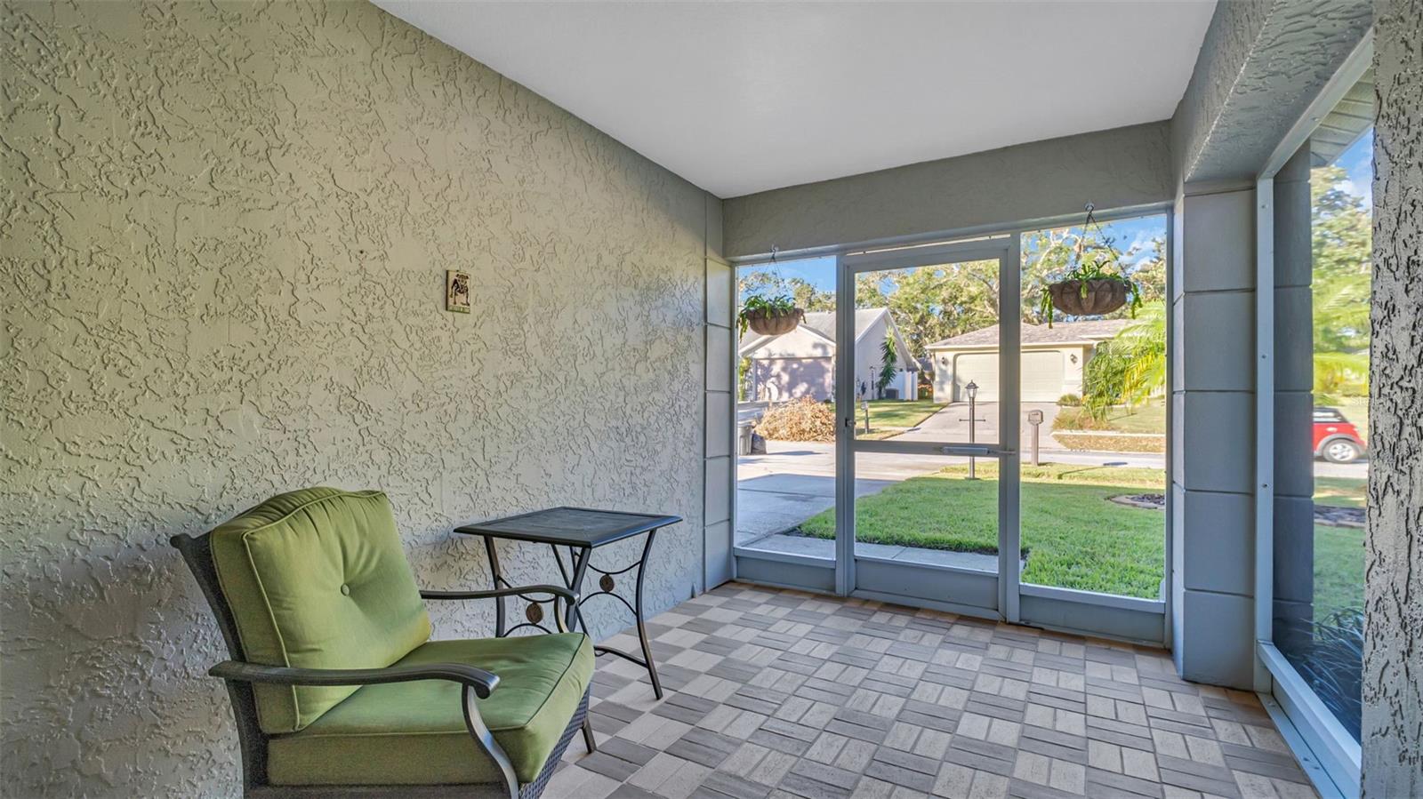 Welcoming Screened Front Porch with Elegant Double Leaded Glass Doors with in door blinds.