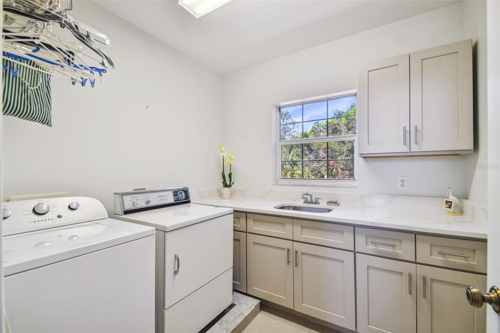 Large Laundry Room with sink,window, built in cabinetry & stone countertops on the same floor as 3 of the bedrooms!