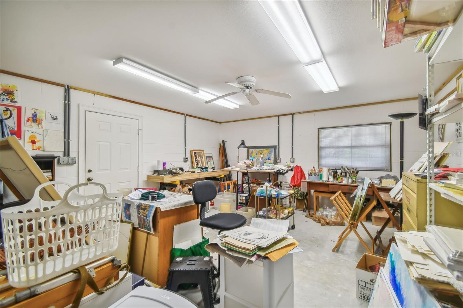 Another view of 3 car garage - note door to outdoor covered patio and unheated space on left up step w/ private entrance to to the home. Details of owner exemplified by space on right  to store extra floor wood