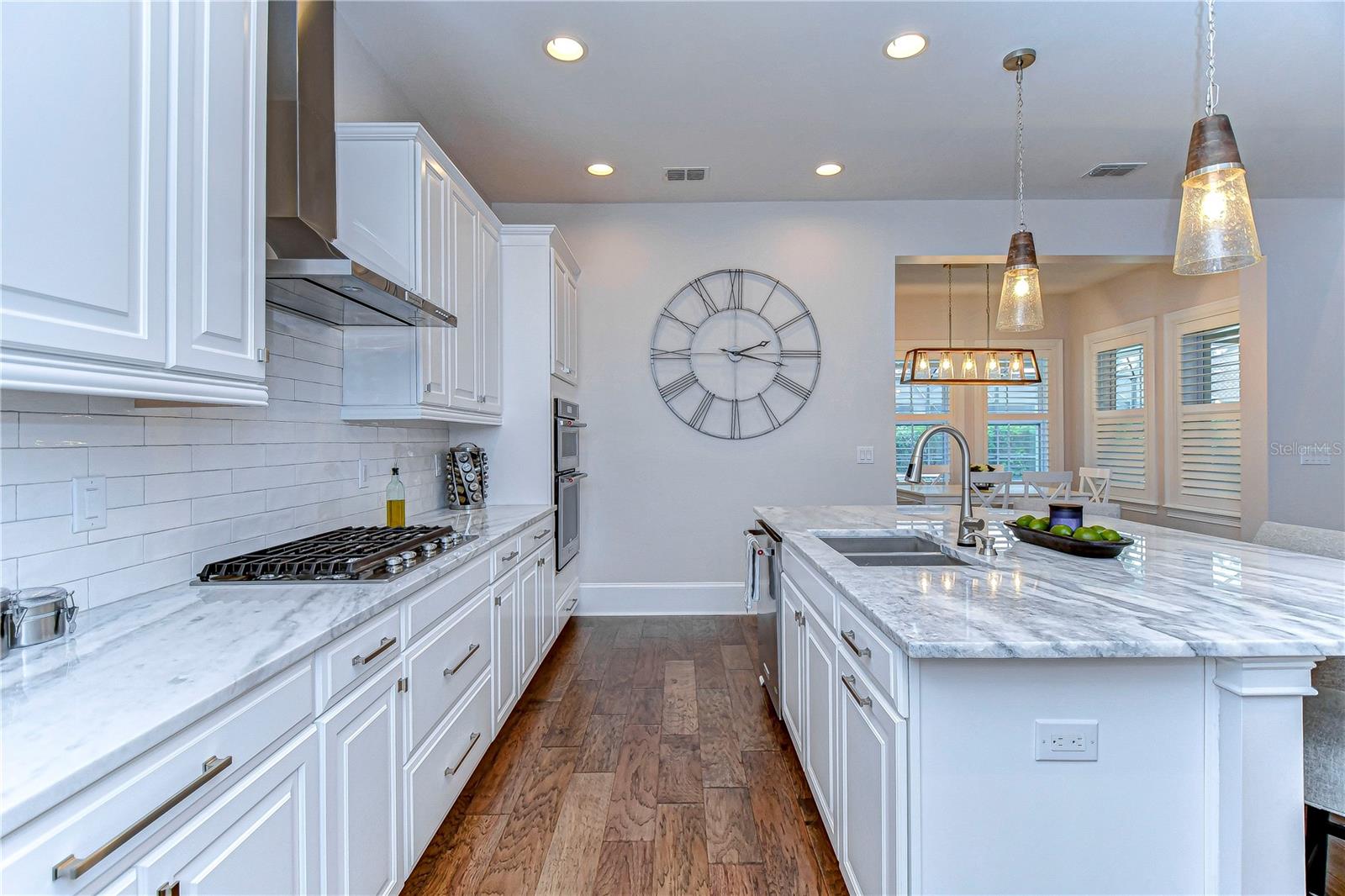 Stylish tile backsplash, 42” white cabinets topped with crown, double oven and 5-burner gas stove!