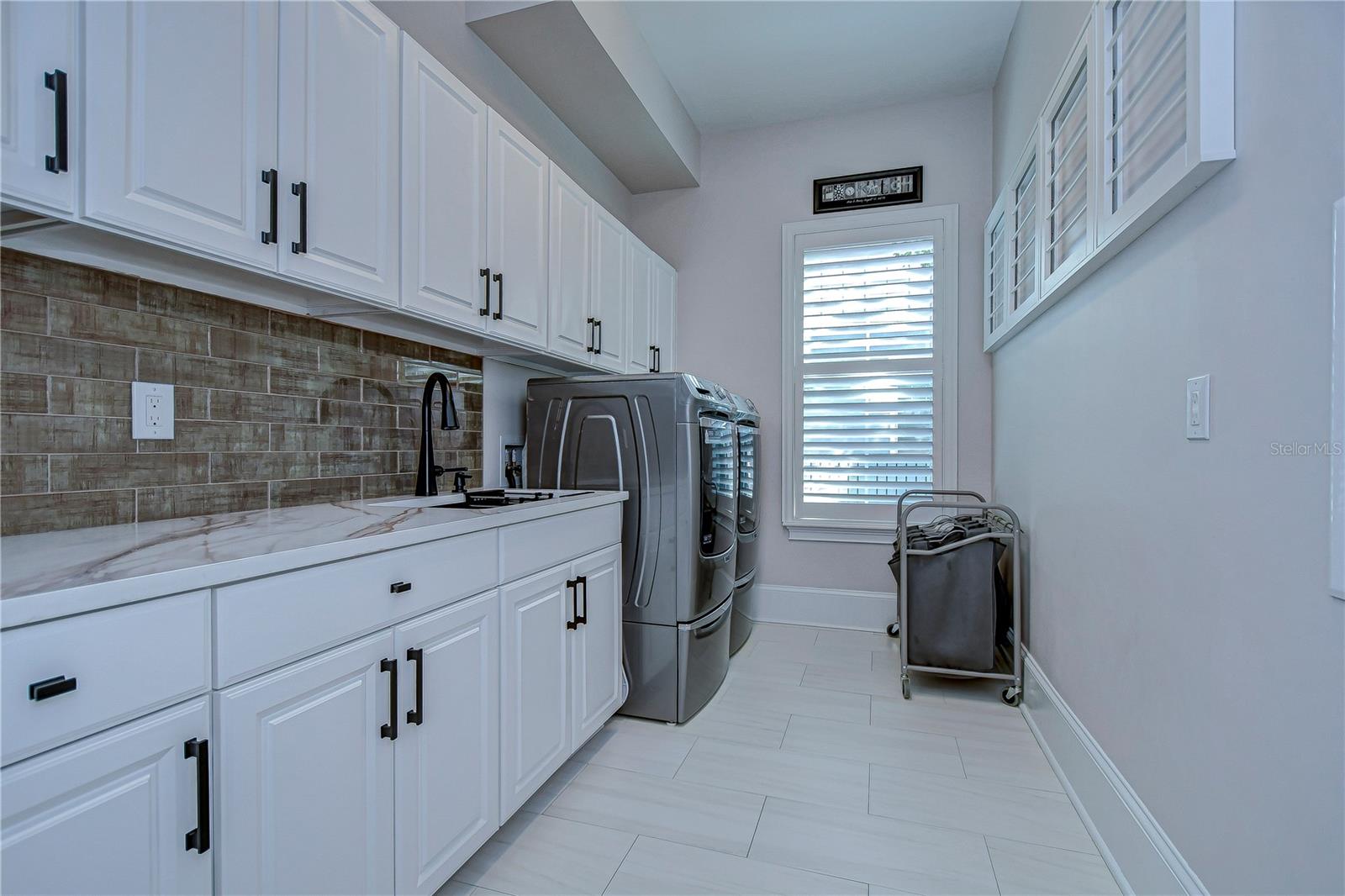 Laundry room with cabinets for extra storage, tons of counterspace and sink!