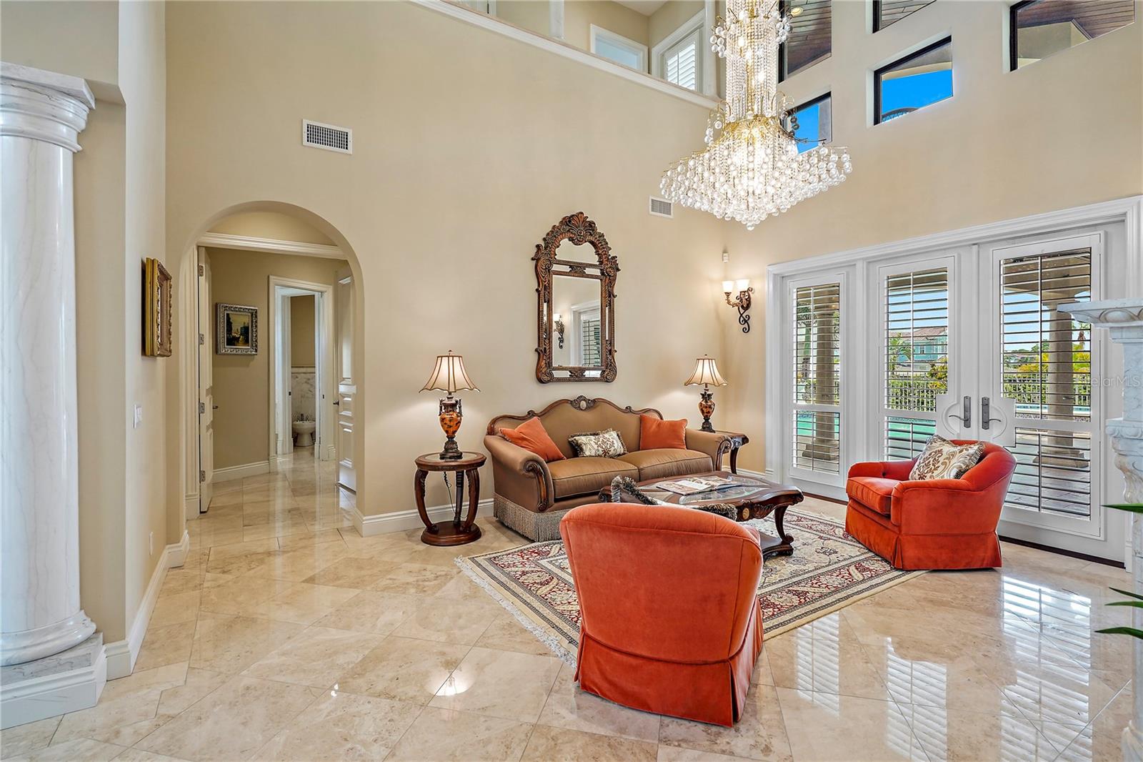 Foyer and Living Room with Gas Fireplace, Crystal Chandelier and double French Doors leading to pool3341 Gulf Blvd, Belleair Beach, FL