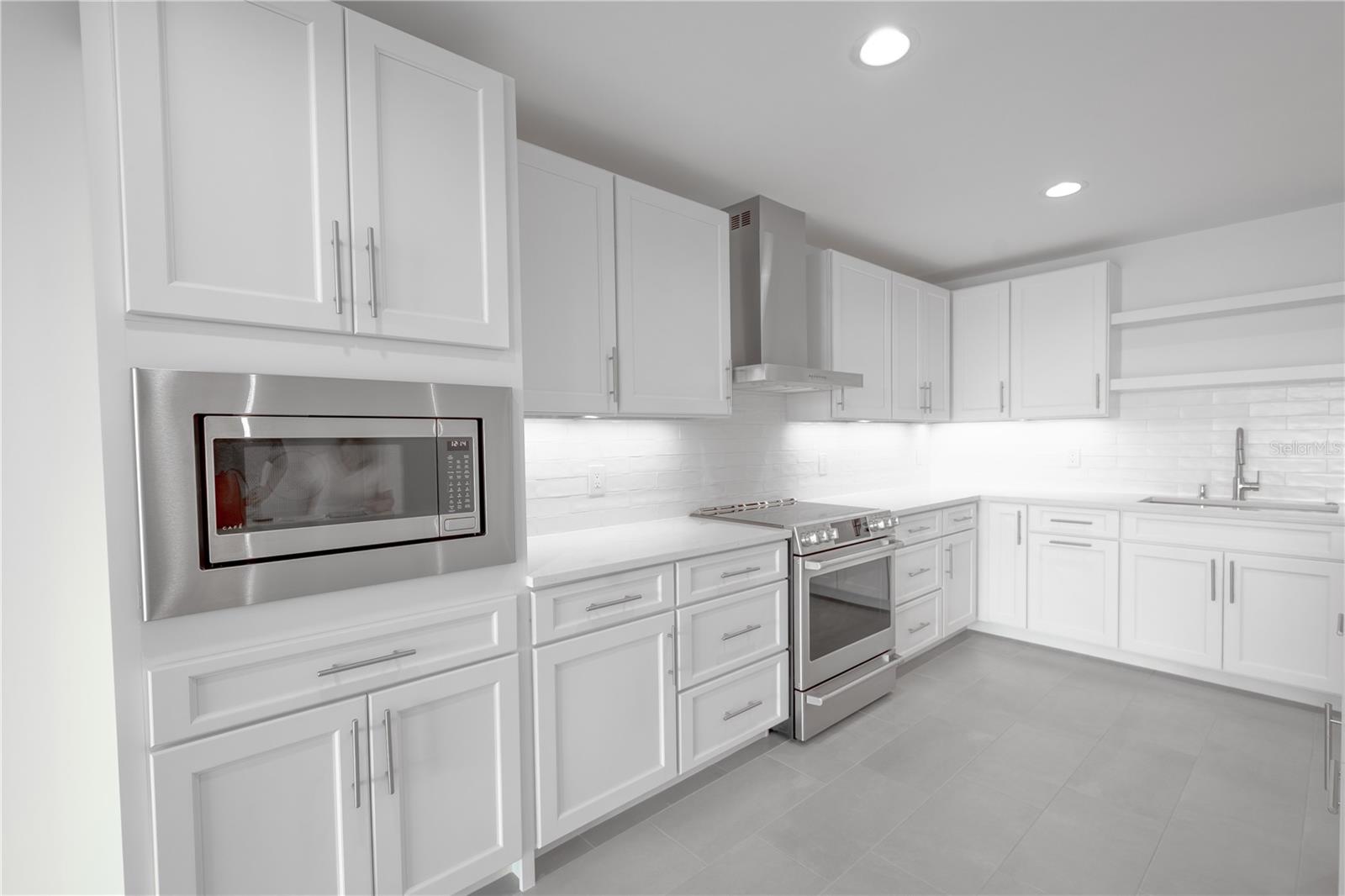 The gray porcelain tile floor perfectly complements the stainless steel Café appliances.