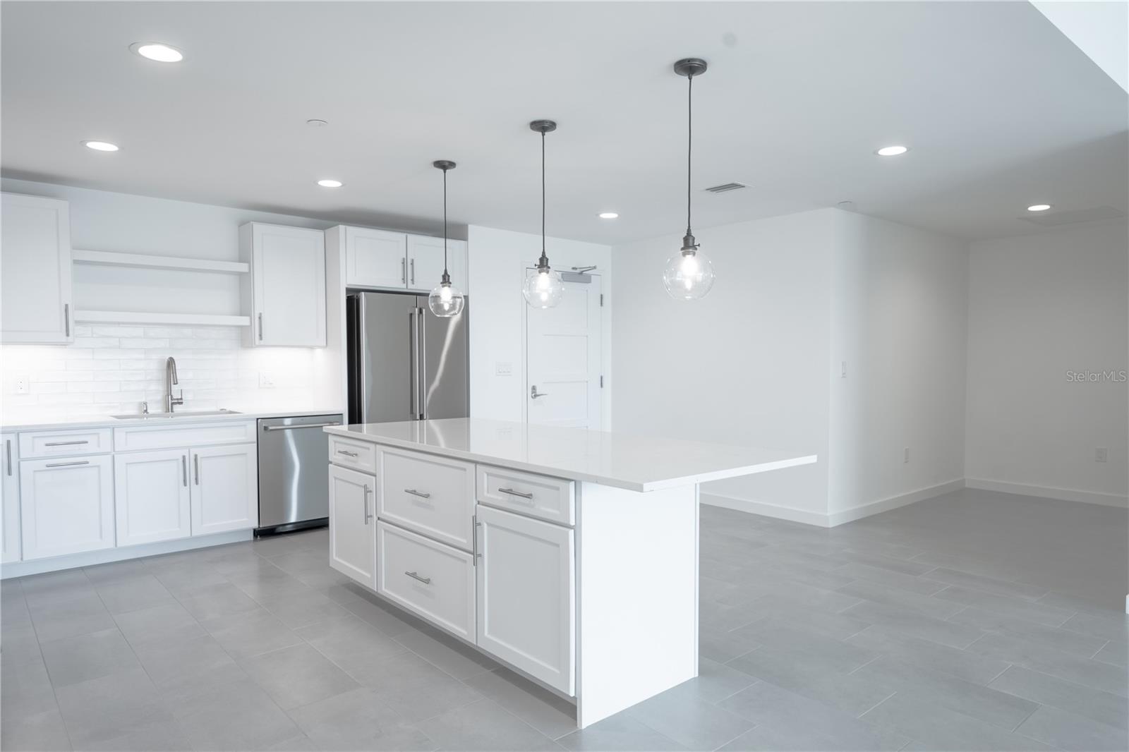 The kitchen island features a breakfast bar with comfortable seating for 4-5 people.