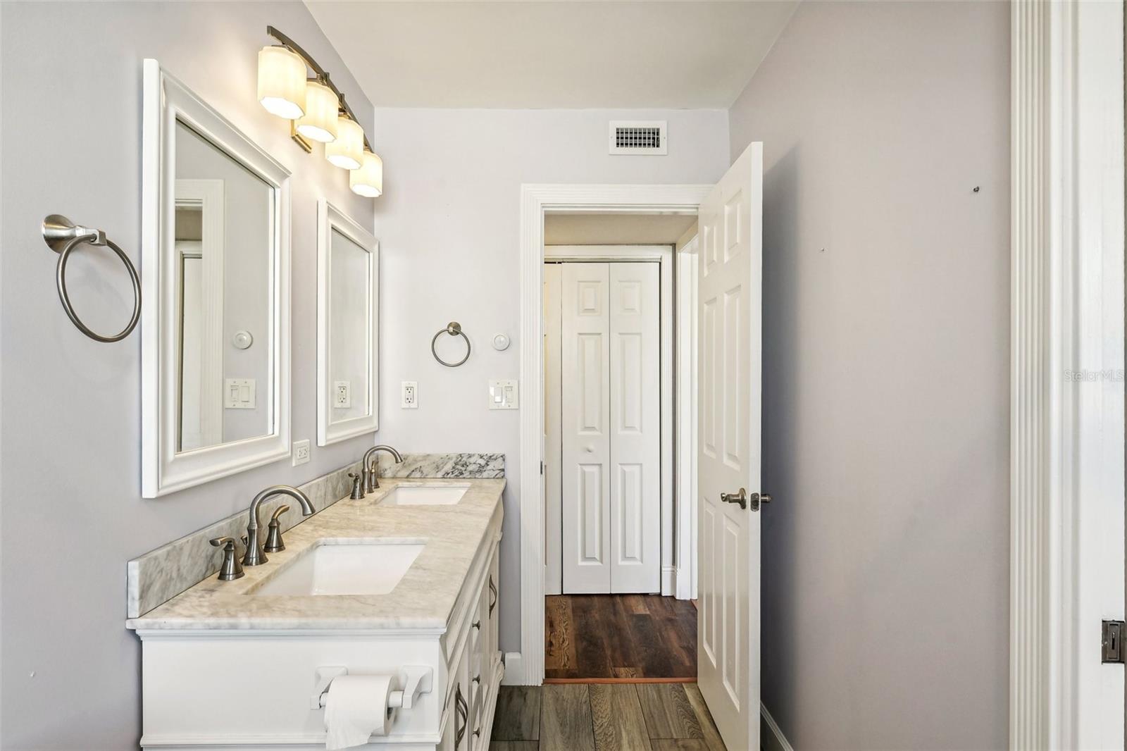 primary bathroom with pocket door to primary bedroom as well as hallway