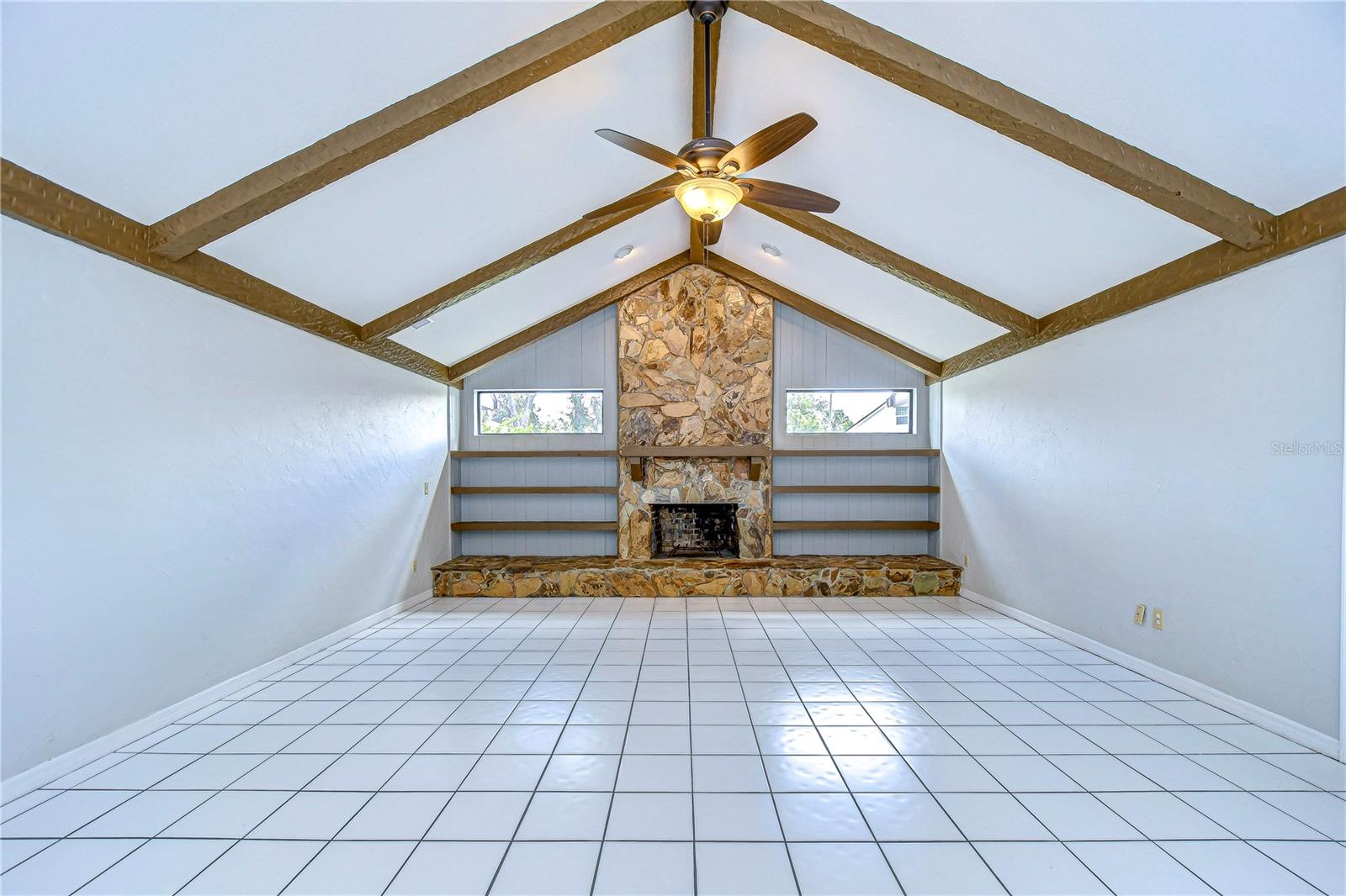 Soaring cathedral ceilings accented by rustic wood beams and a cozy wood-burning fireplace!