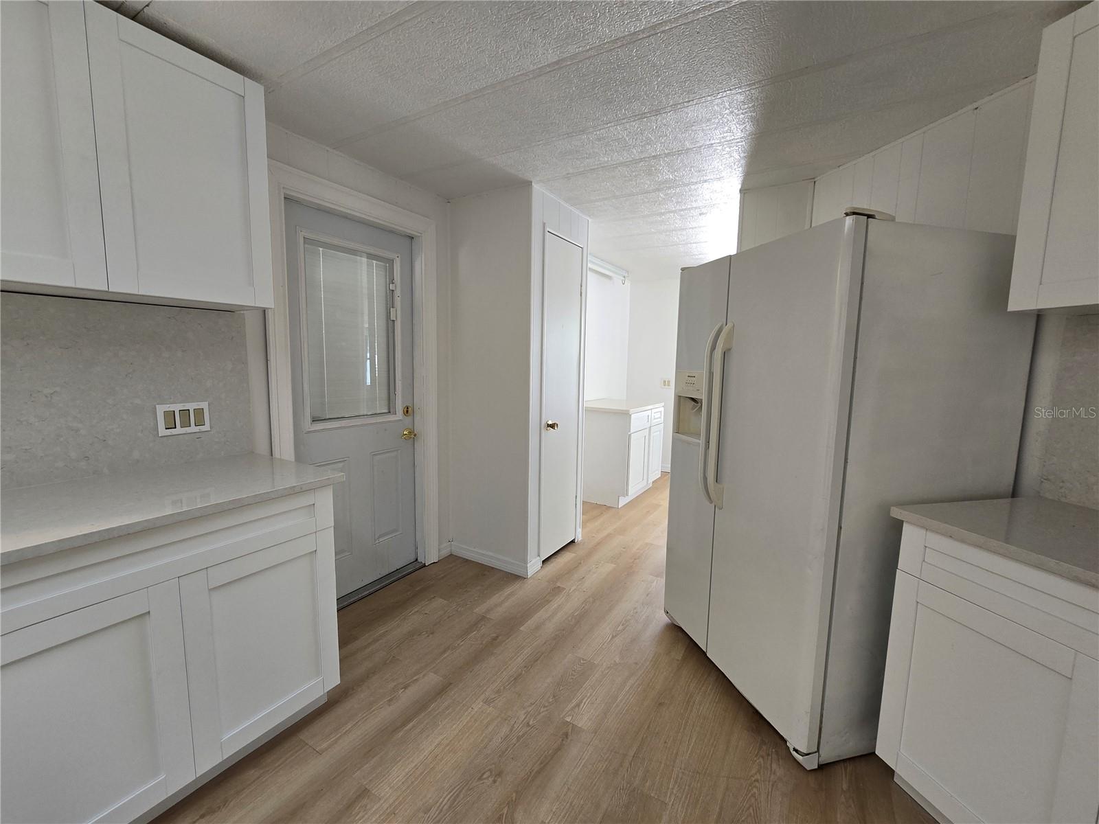 View in kitchen towards outside door and pantry