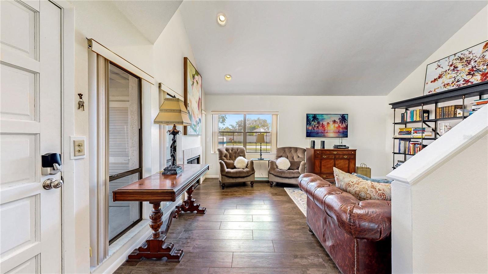 The living room with beautiful wide plank wood look porcelain tile and fireplace!