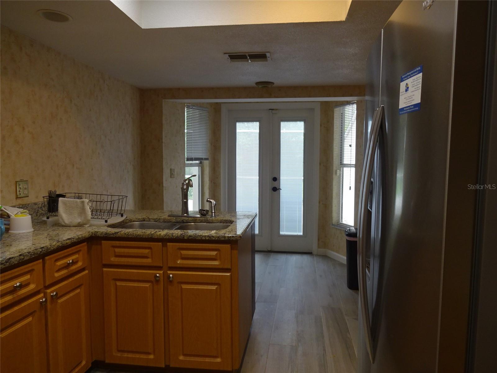 Kitchen looking down to breakfast nook and opening onto large screened patio