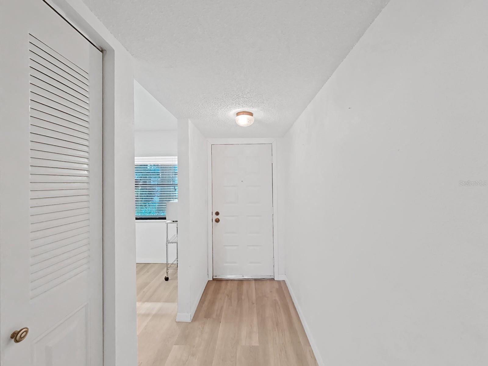 Hall to Front Entryway, Closet and Kitchen to the left.