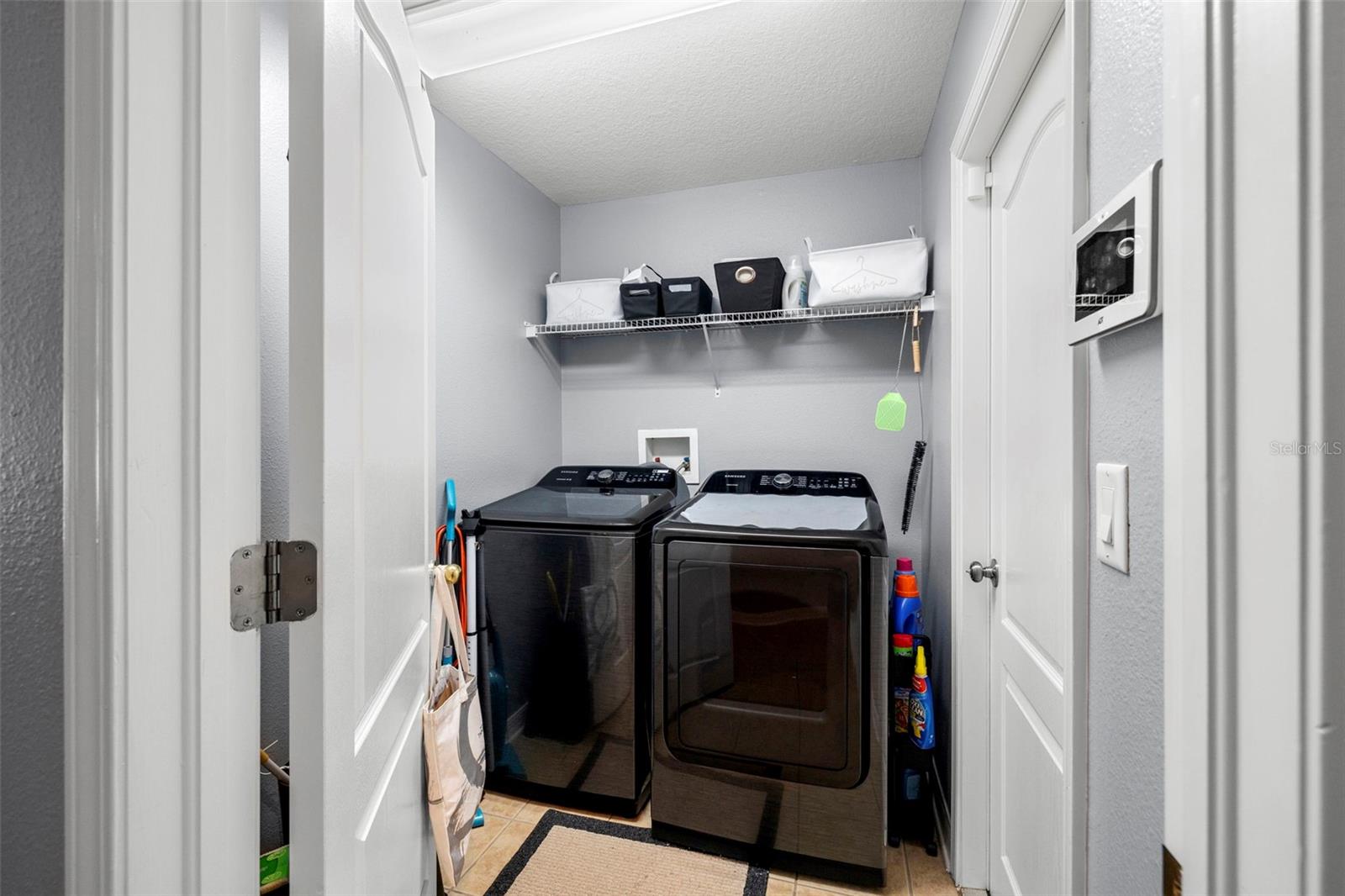 Laundry room with door to the garage and security system (on the wall).