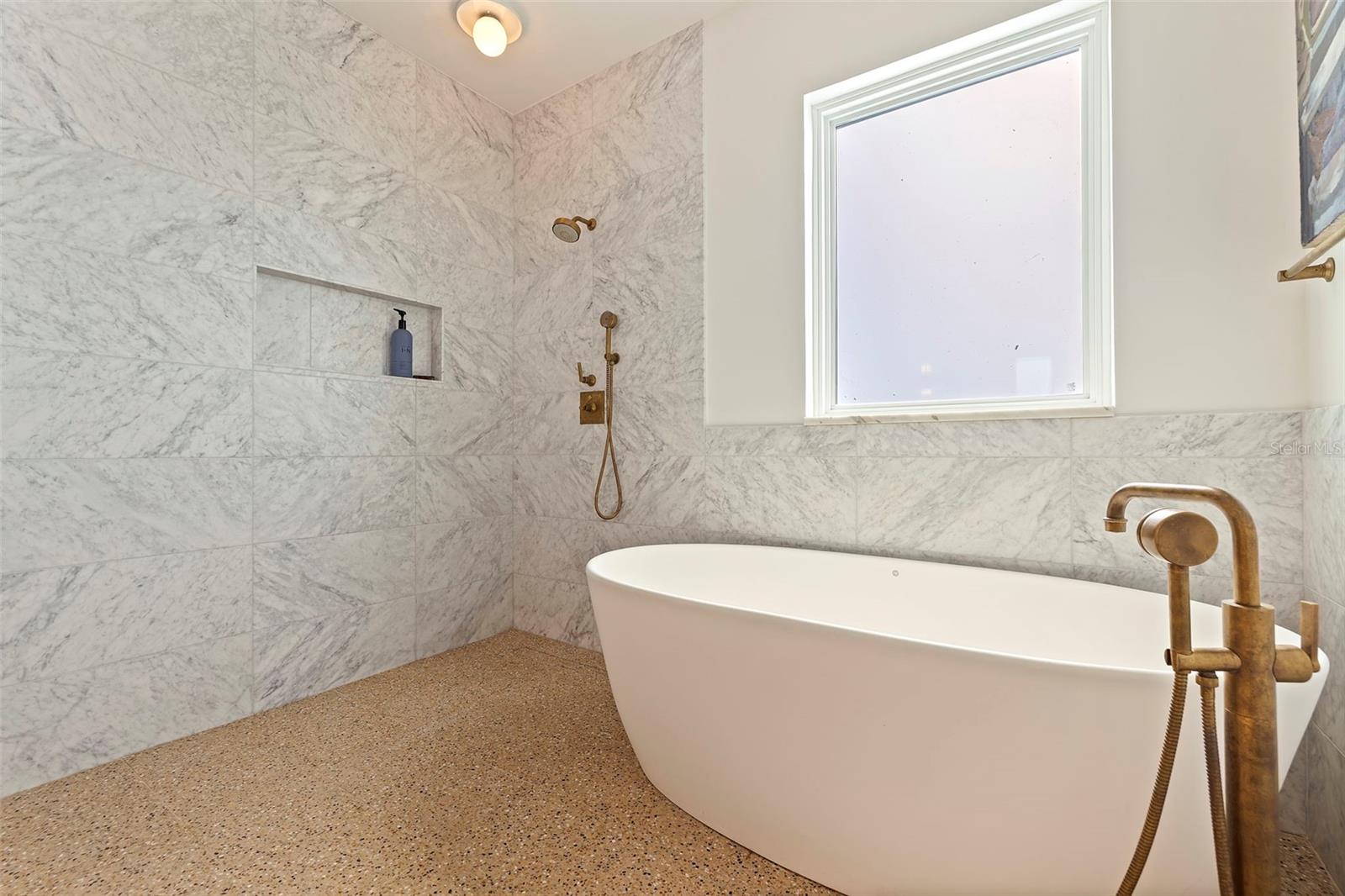 The chic terrazzo flooring in the wet room combining the ease of the tub or shower.