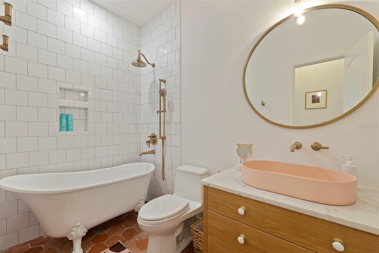 En suite bathroom with Cle tile, artisan sink and claw foot tub.