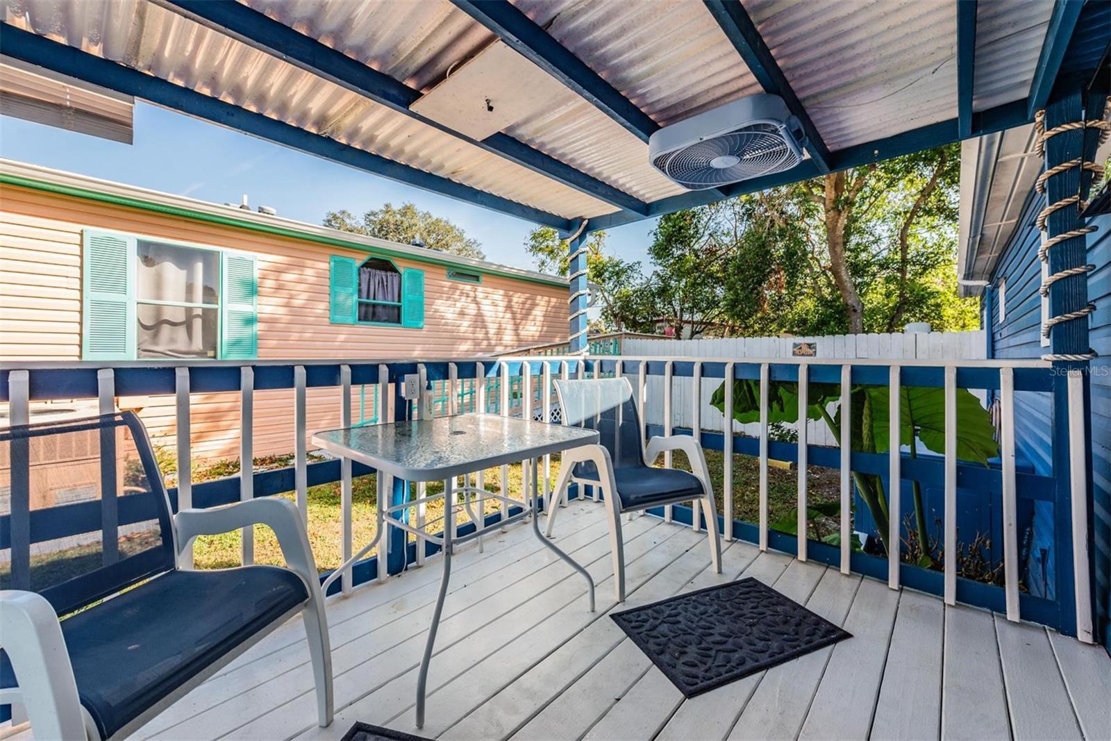 Open porch with mounted TV.  Steps to the front yard.