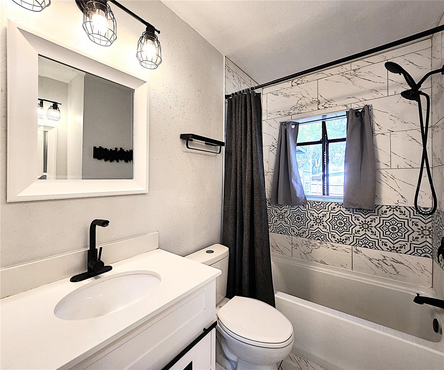 Bathroom includes split vanities, tiled shower/tub combo