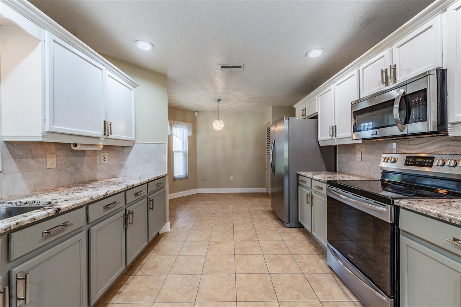 Two tone kitchen with Custom backsplash in this functional kitchen.