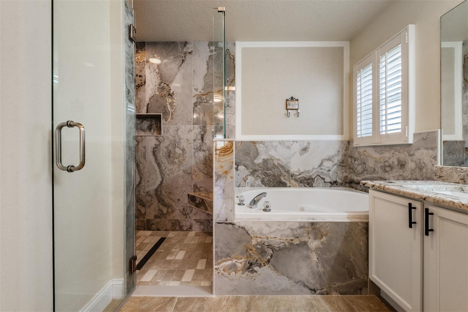 Frameless shower, Marble tiled shower with spa and jetted soaking tub for a luxurious bath experience