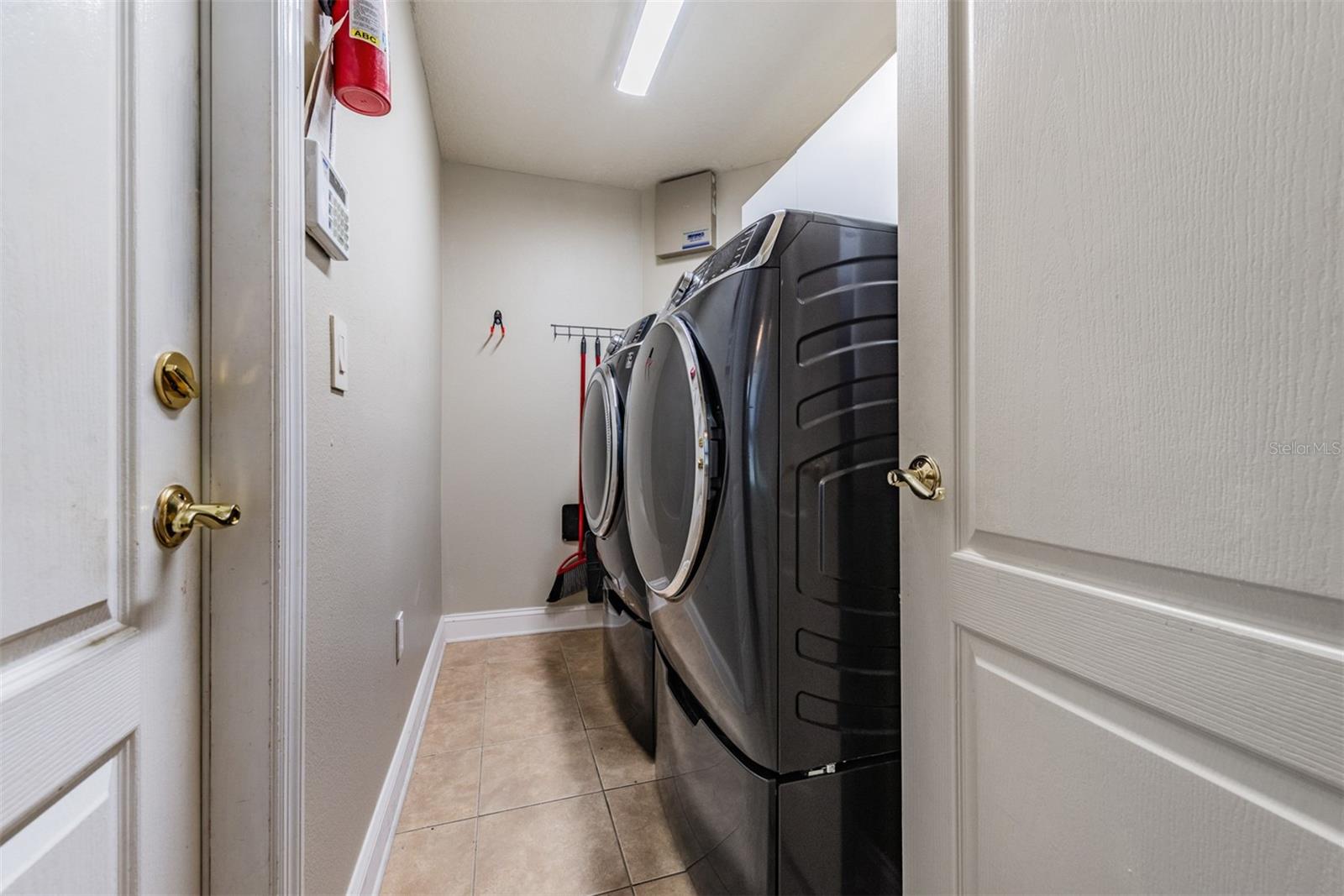 High efficiency washer and dryer with pedestals in the laundry room, just off the garage.