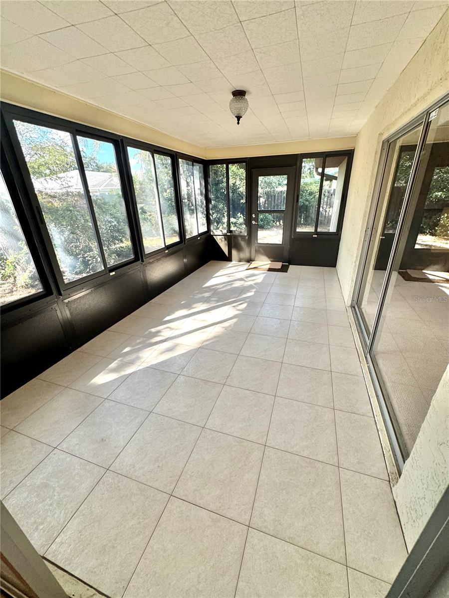 Large glass enclosed lanai with nice ceramic flooring.