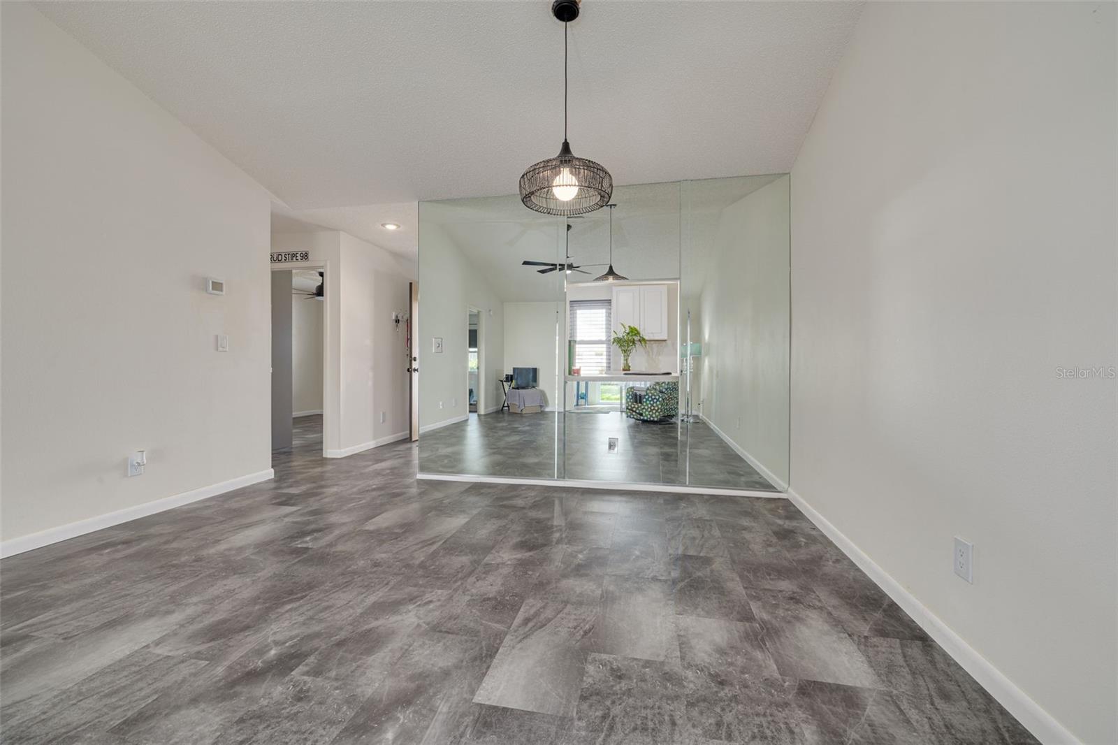 View of Living & Dining from Florida Room. Pass-through opening in Mirrored Wall to Kitchen.